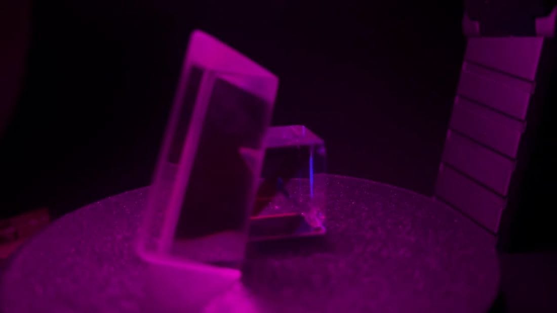 Crystal specimen on a rotating turntable lit with magenta display lighting